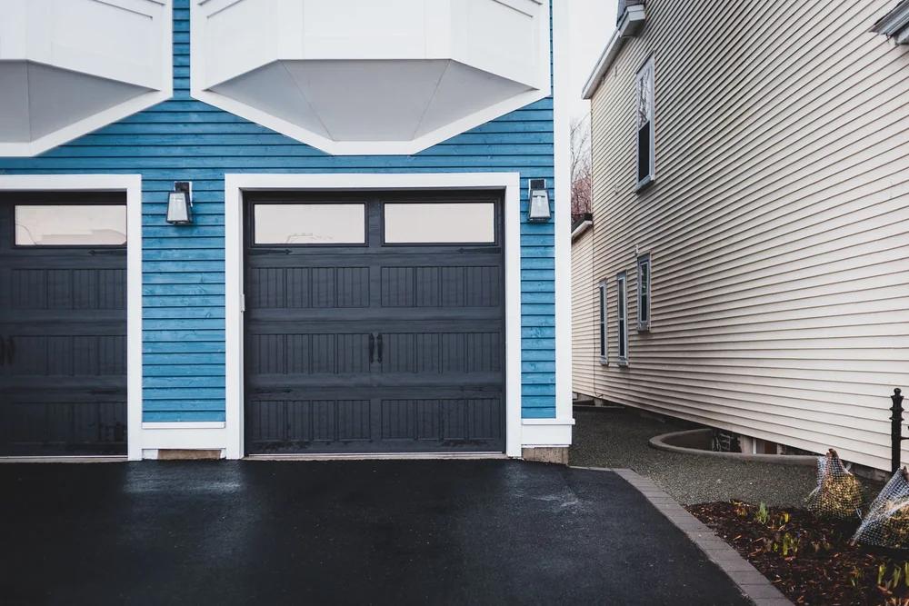 Blue house with charcoal carriage-style garage doors
